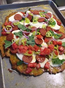 summer squash pizza crust with toppings added, before final baking.